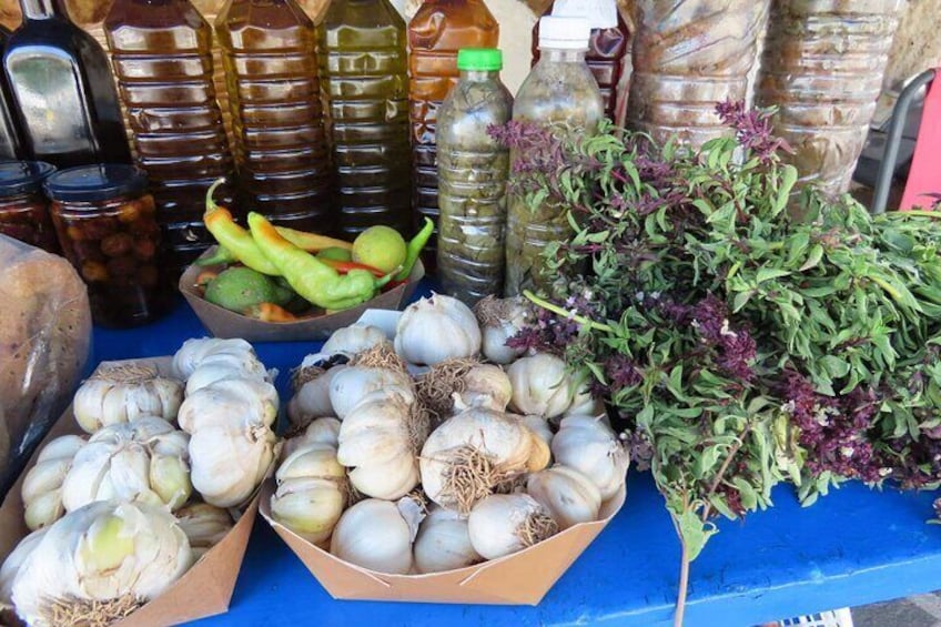 A market stall with onions, garlic, green chilies, and leafy greens. 5