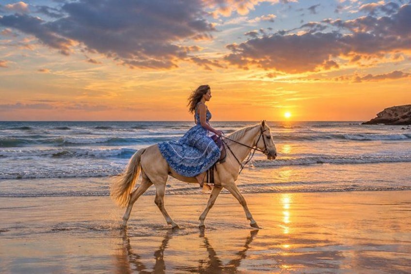 A person riding a horse on a beach at sunset. 5