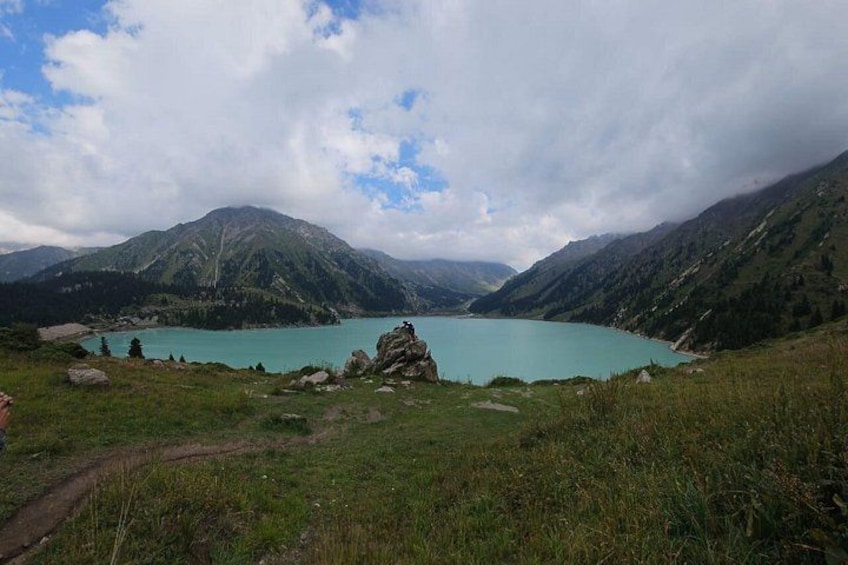 A mountain landscape with a turquoise lake, rocky outcrops, and a clear sky. 1