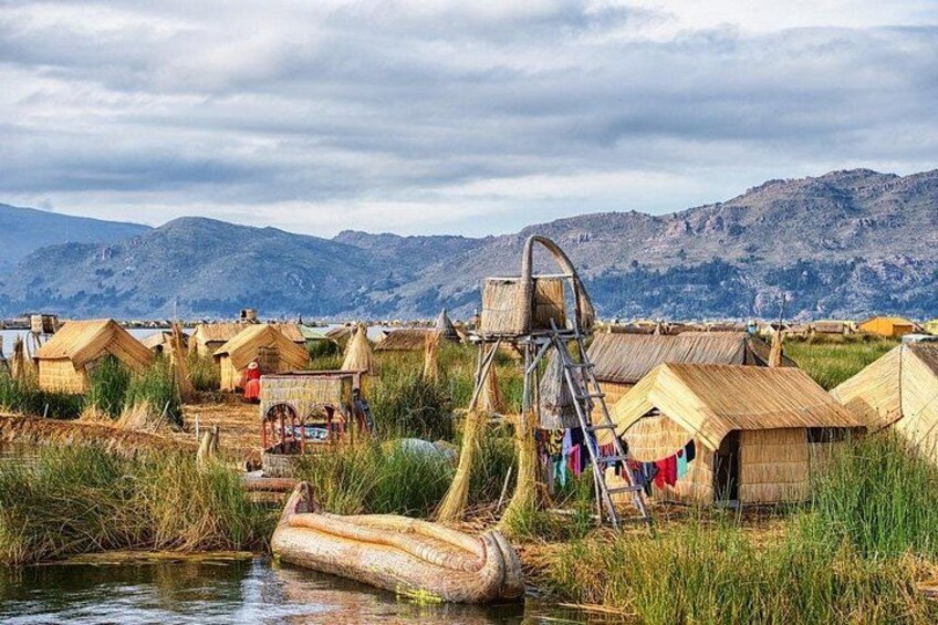 A rural landscape with traditional thatched-roof houses, a water wheel, and a river. 3