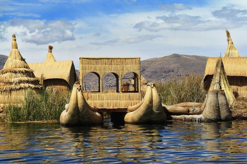 A traditional thatched-roof structure with a central viewing platform, surrounded by water and reed huts. 3