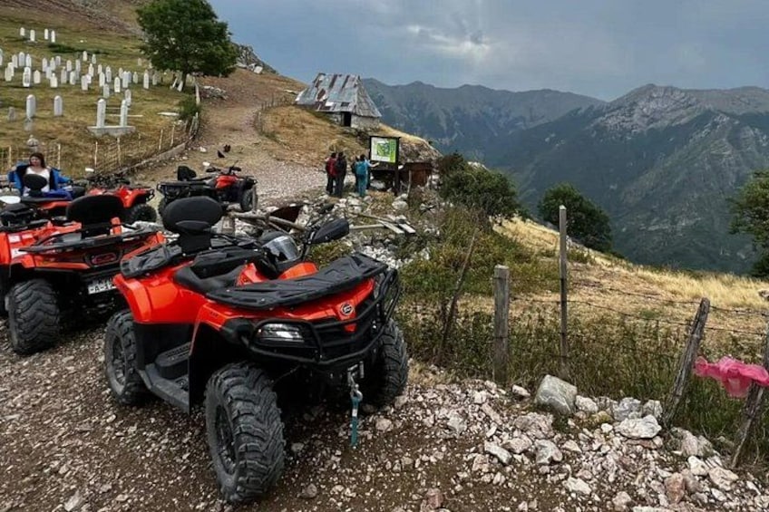 ATVs parked on a rocky path with a mountainous landscape in the background. 4