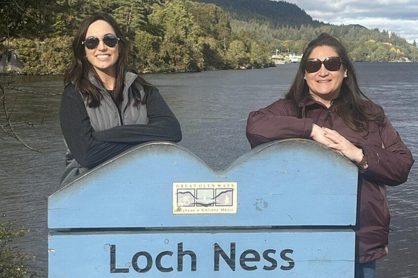 Two people standing by a sign that reads 'Loch Ness.' 2