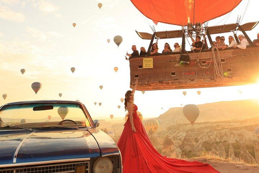 Un coche antiguo, una mujer con un vestido rojo y un globo aerostático con pasajeros. 2