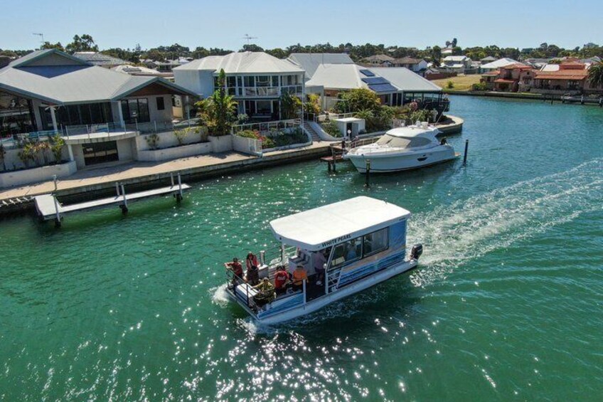A boat on a calm waterway with houses in the background. 1