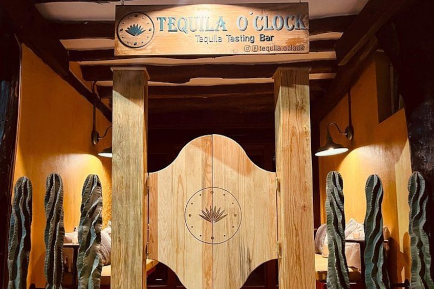Una puerta de madera con un reloj y un letrero que dice 'Tequila O'Clock Tequila Tasting Bar'. 1