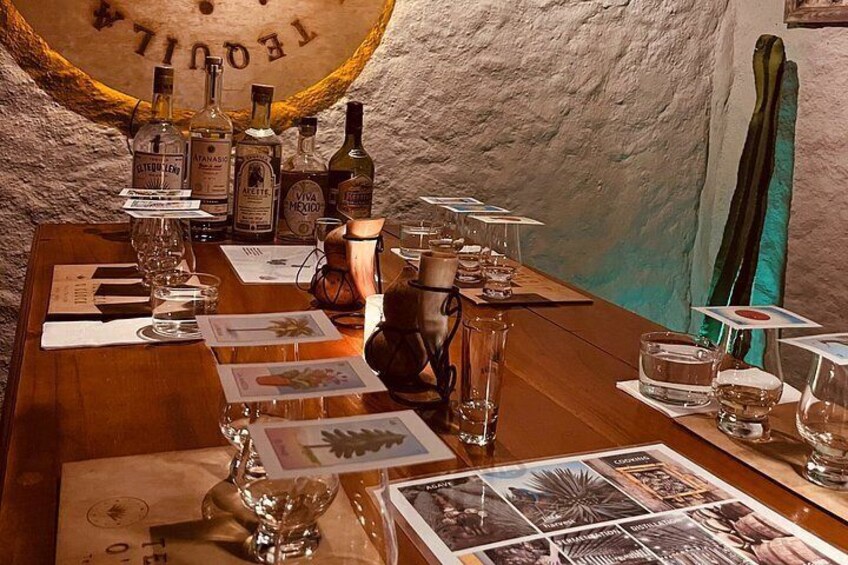 Un bar avec des bouteilles, des verres et des cartes de boissons sur une table en bois. 5