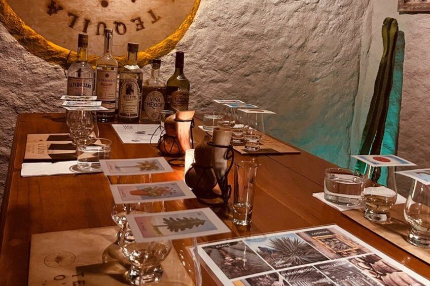 Una mesa de madera con varias botellas y copas, rodeada de menús y tarjetas. 1