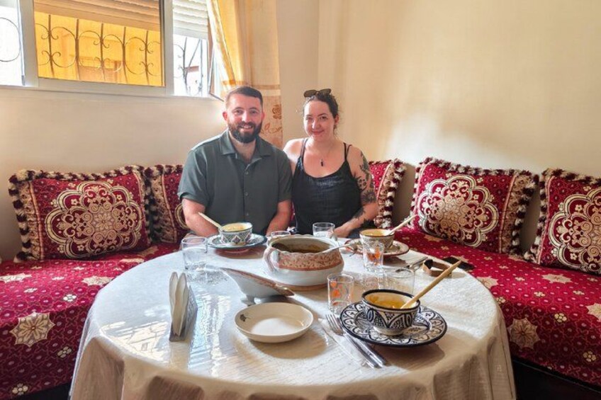 A dining table with plates, glasses, and a bowl of food. 2