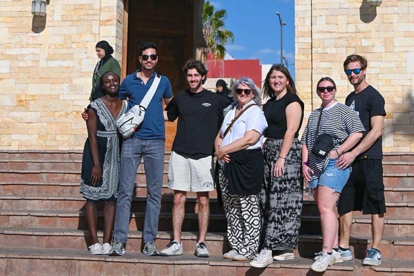 Un grupo de personas de pie en los escalones frente a un edificio de piedra. 5