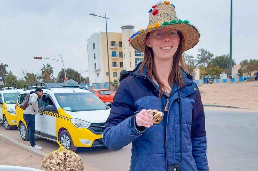 Una persona sosteniendo un aperitivo, un taxi amarillo y un edificio al fondo. 2