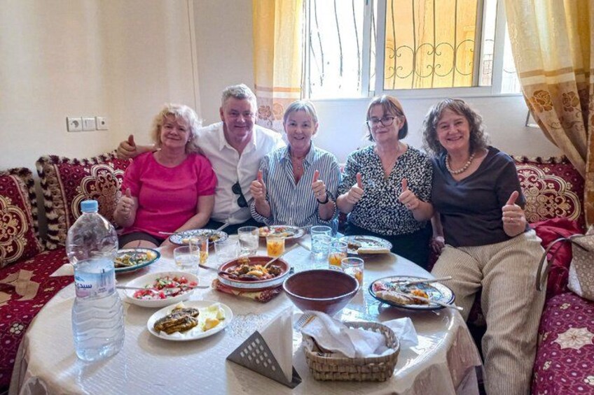 Un grupo de personas sentadas alrededor de una mesa con comida y bebidas. 2