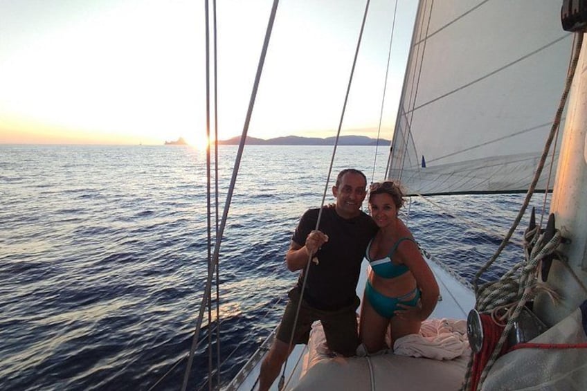 A sailboat on the water with a sunset in the background. 2
