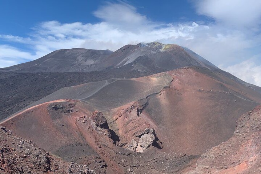 Un paisaje volcánico con una montaña destacada, cráter y terreno accidentado. 4