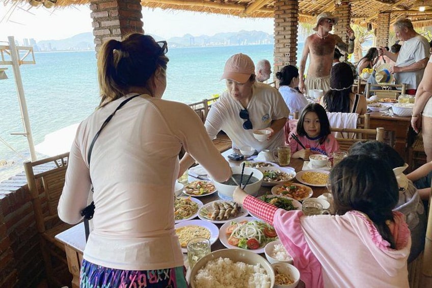 A group dining at a seaside restaurant with a view of the ocean. 4