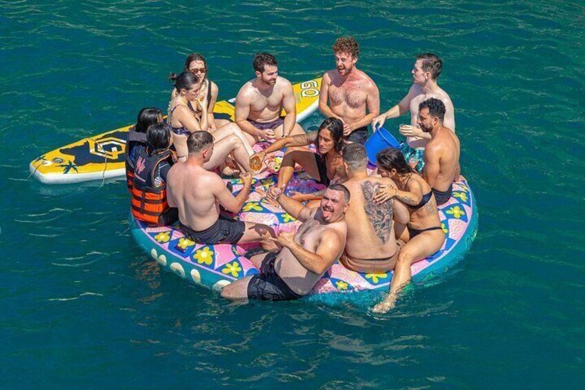 A group of people on a colorful inflatable raft in the water. 2