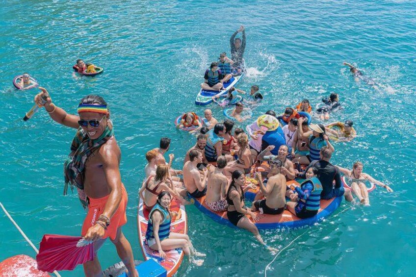 A group of people on a boat in a body of water, some wearing life jackets. 1