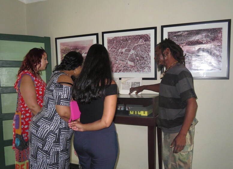 A group of people examining framed maps on a wall. 2