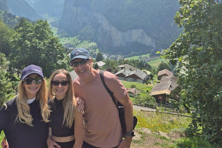 Three people standing with a mountainous landscape in the background. 5