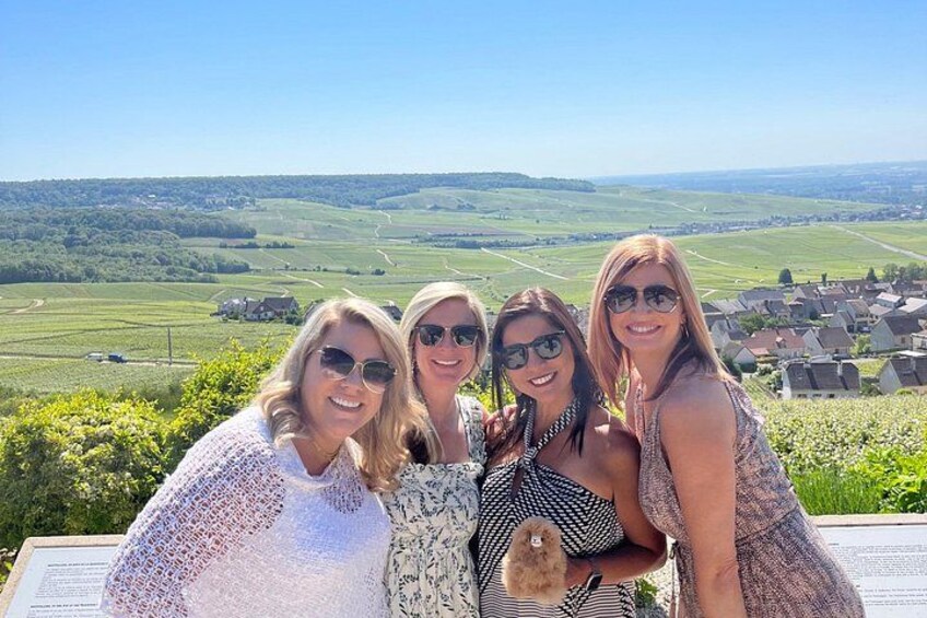 A group of people on a terrace with a rural landscape in the background. 3