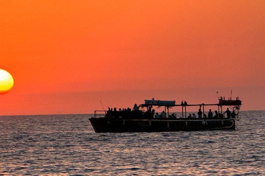 Un bateau avec des personnes à bord, au coucher du soleil. 2