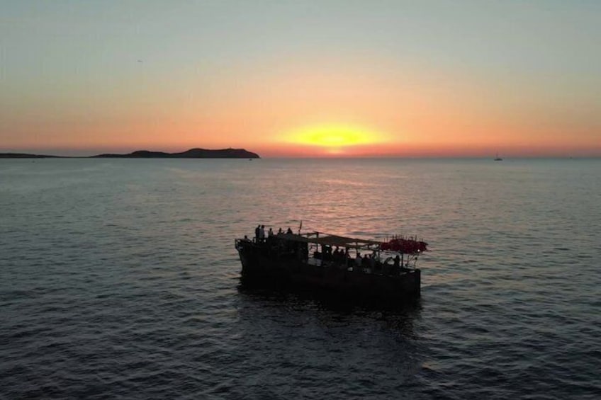 Een boot met mensen op een rustige zee bij zonsondergang. 5