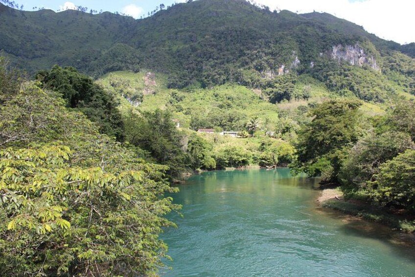 A river winding through a forested valley with hills in the background. 5