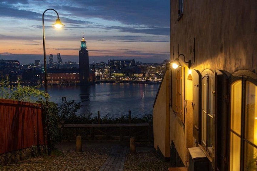 Un paisaje urbano nocturno con un río, una torre destacada y un edificio con ventanas iluminadas. 3