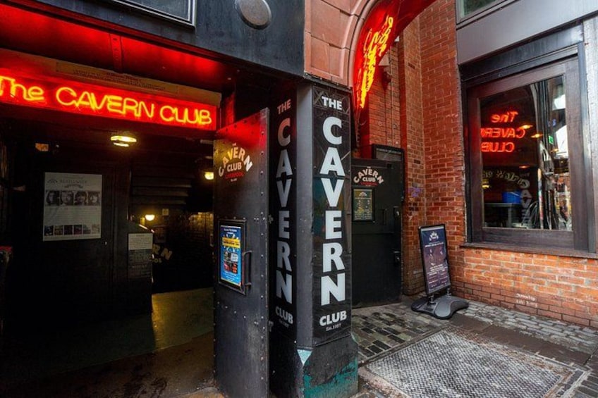 The entrance to The Cavern Club, a brick building with neon signage. 2
