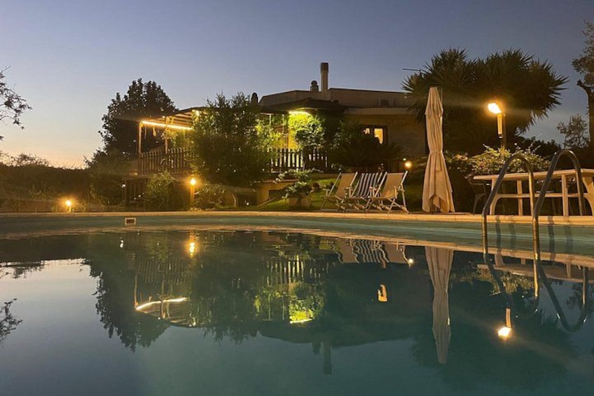Une piscine au crépuscule, avec une maison en arrière-plan. 2