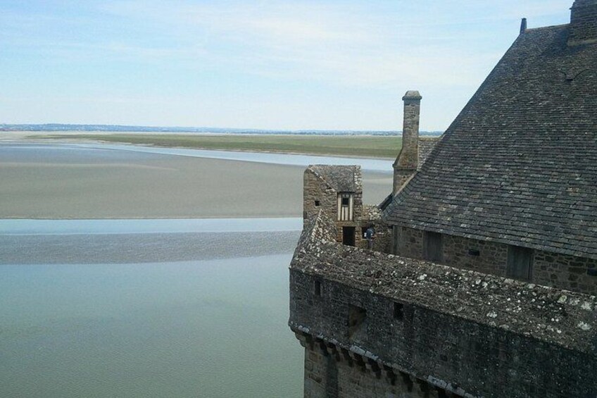 A coastal building with a view of a calm sea and a flat landscape in the distance. 4