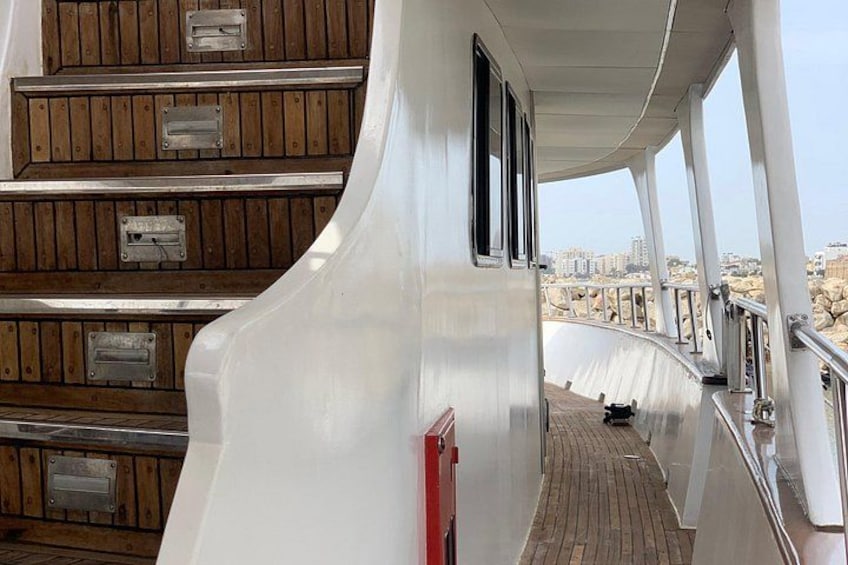 A curved deck with wooden railings and a cityscape in the background. 3