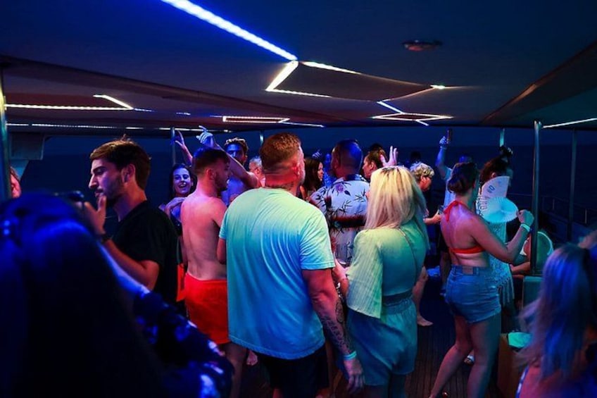 A crowded indoor space with people dancing and socializing. 5