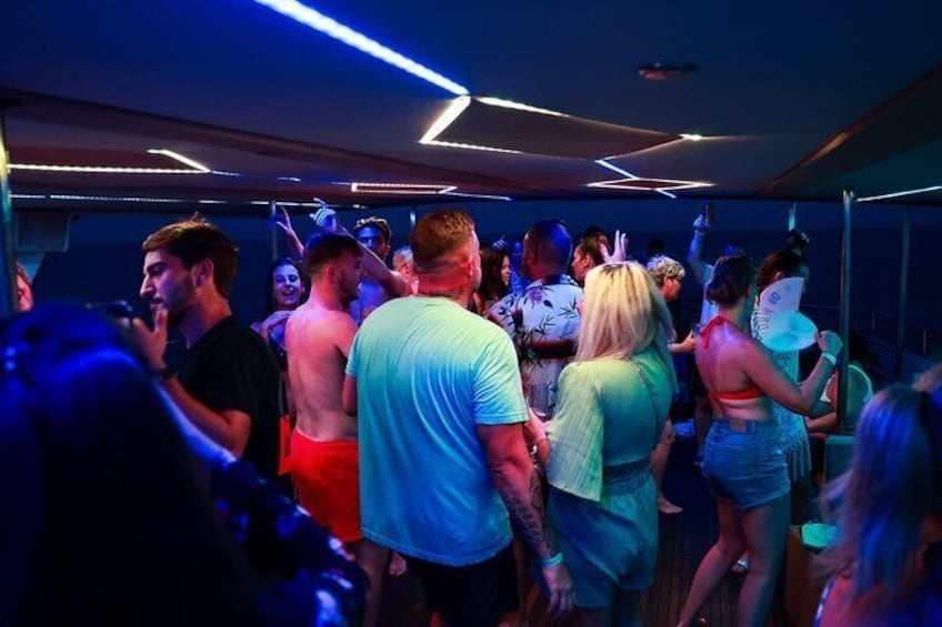 A crowded indoor space with people dancing and socializing. 1