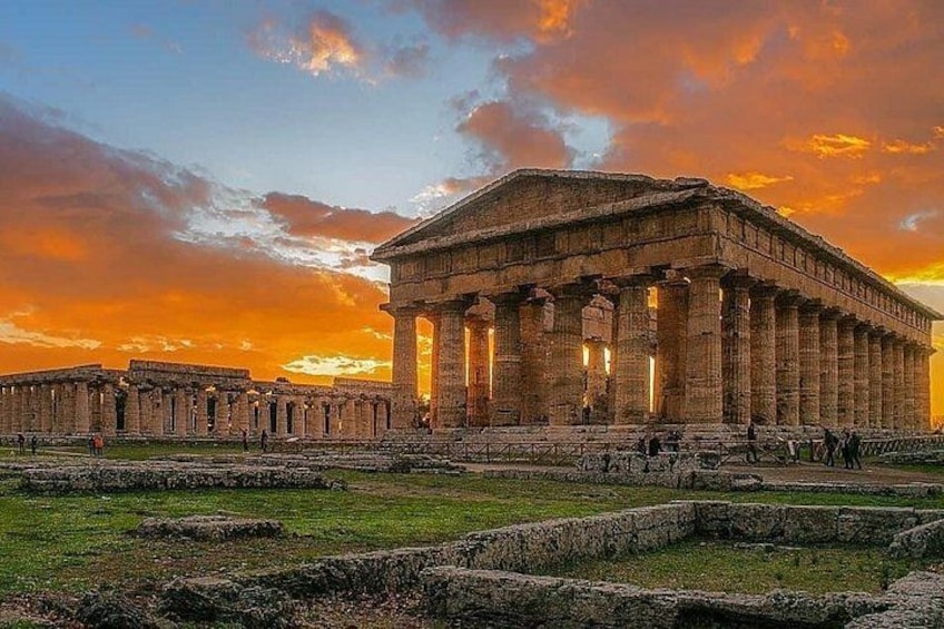 Un antico tempio greco con colonne e un'area erbosa circostante. 1