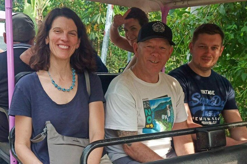 People seated on a bus with a tropical backdrop. 3