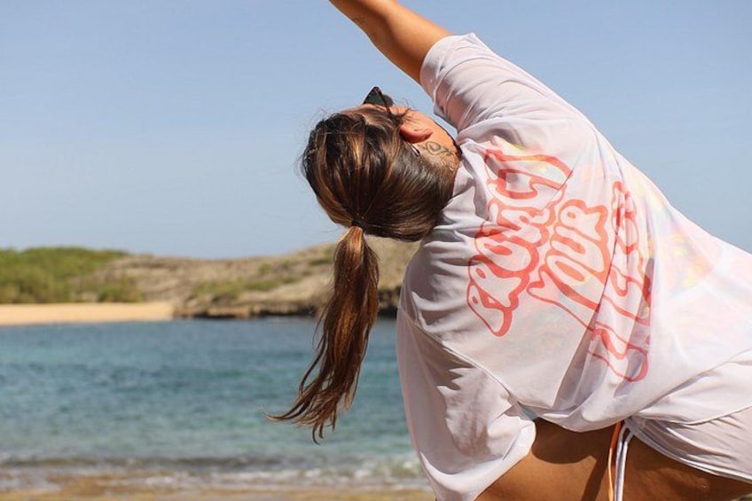 A person stretching by the seaside with a clear sky and calm waters. 4