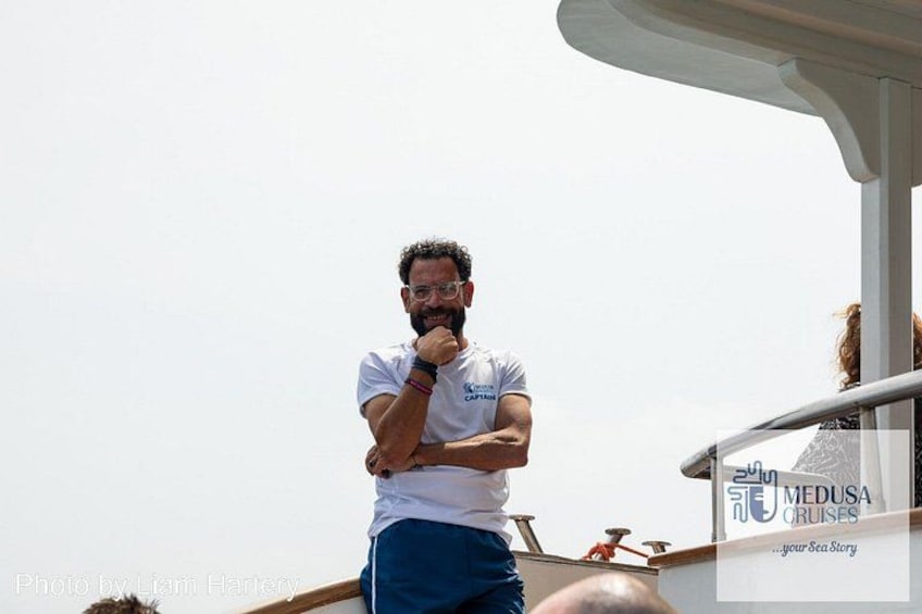 A person standing on a boat deck with a logo that reads 'MEDUSA CRUISES.' 2