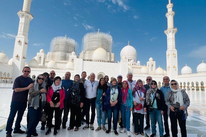 Een groep mensen staat voor een groot wit gebouw met koepels en minaretten. 3