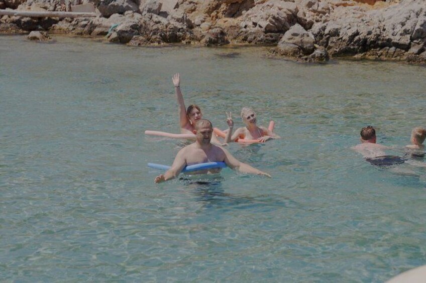 People in a swimming pool with rocks in the background. 5