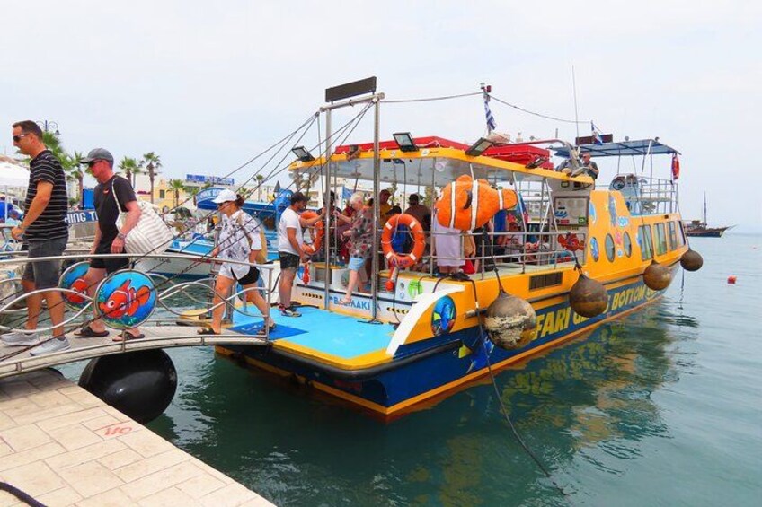 A colorful boat docked at a pier with people boarding and disembarking. 3