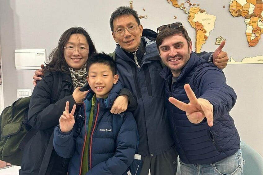 A family of four in an office setting with a world map on the wall. 3