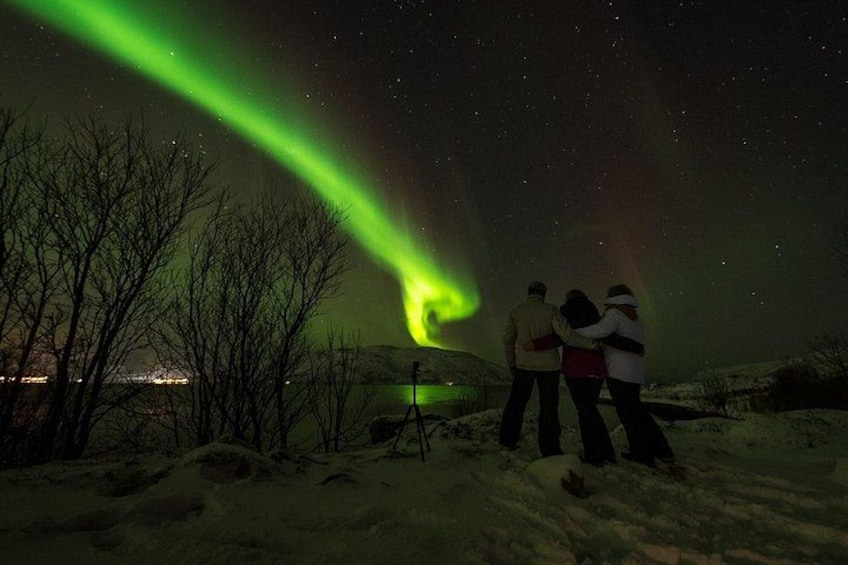 Un grupo de personas observando las auroras boreales en un paisaje nevado. 3