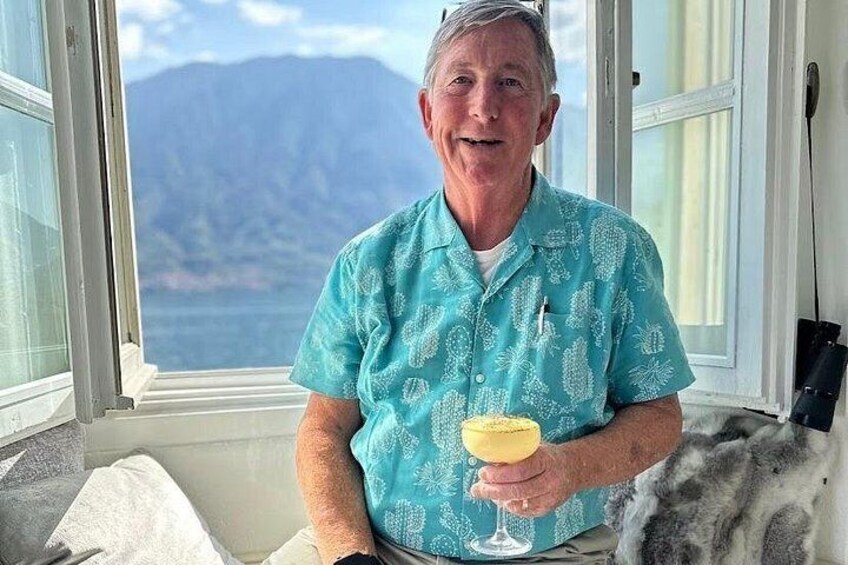 A person sitting by a window with a view of mountains. 1