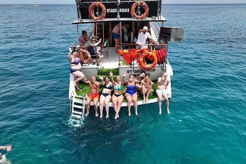 Un grupo de personas en un bote con boyas salvavidas y una escalera. 1