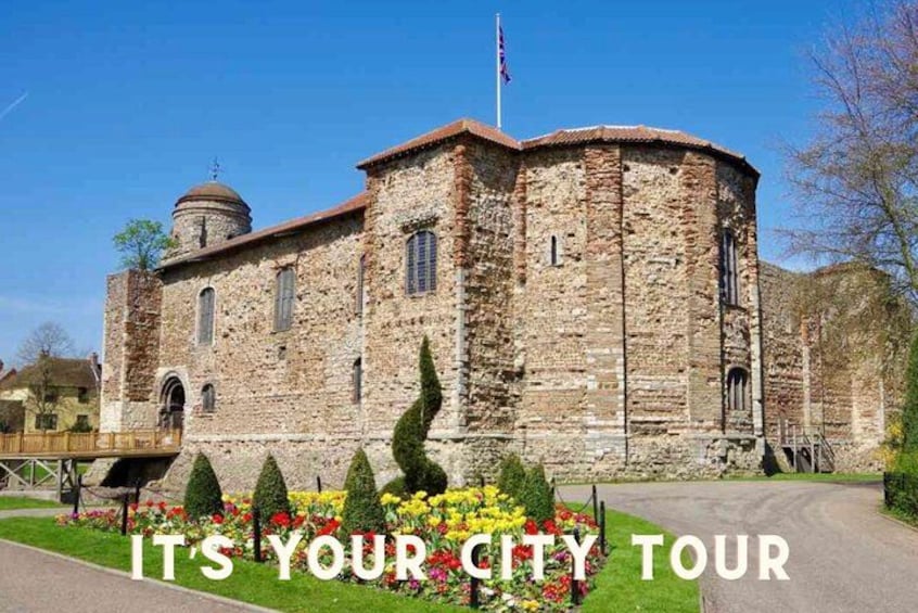 A historic stone building with a dome, a flag, and a well-maintained garden with colorful flowers. 4