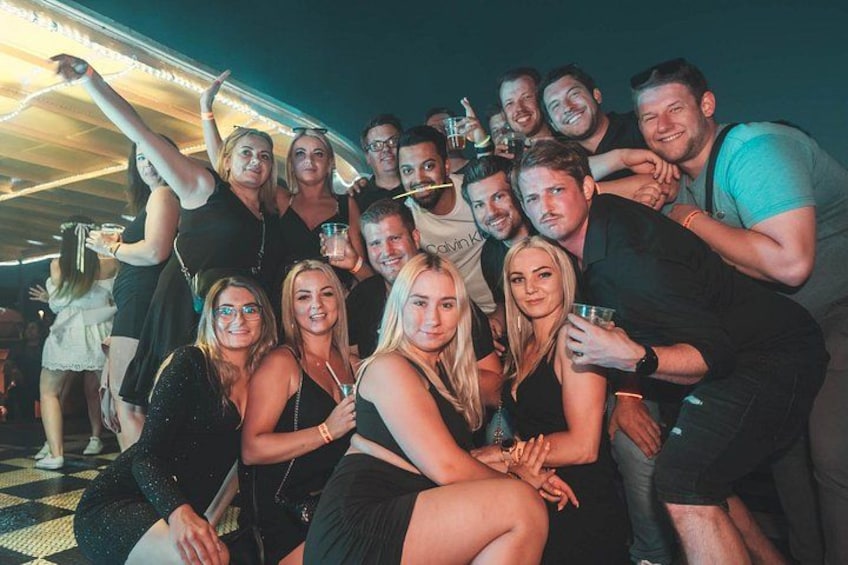 A group of people at an outdoor event with string lights overhead. 4
