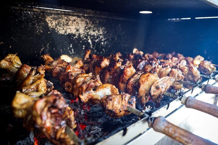 Gran cantidad de pollos asándose a la parrilla sobre fuego abierto. 2