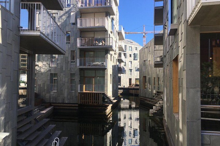 Un estrecho canal entre edificios con balcones y una grúa de construcción al fondo. 4