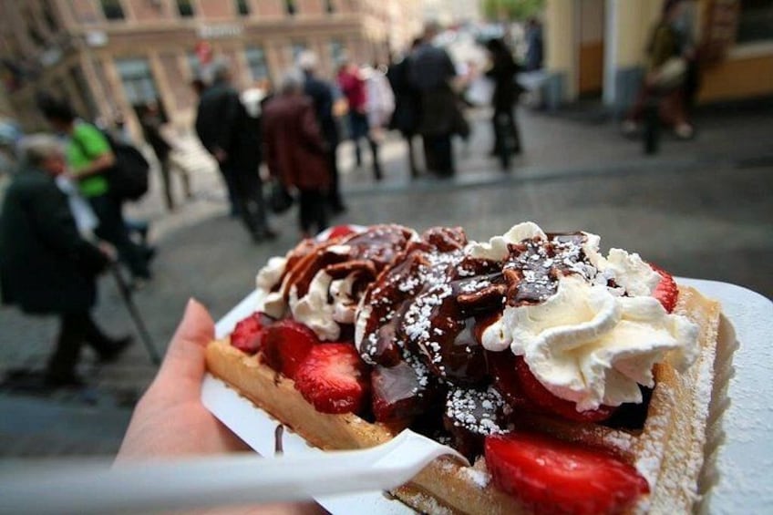 Een wafel met aardbeien en slagroom op een bord. 2